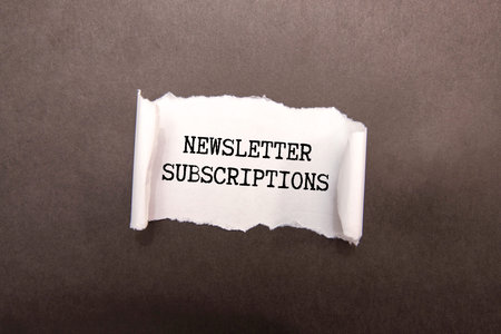 The word Newsletter appearing behind torn brown paper