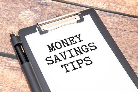 Money Saving Tips text message and piggy bank on wooden background