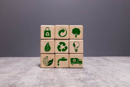 A hand is holding three white cubes with green symbols on them. The cubes are stacked on top of each other, and the symbols on them include a CO2 logo, a globe, and a check markの写真素材