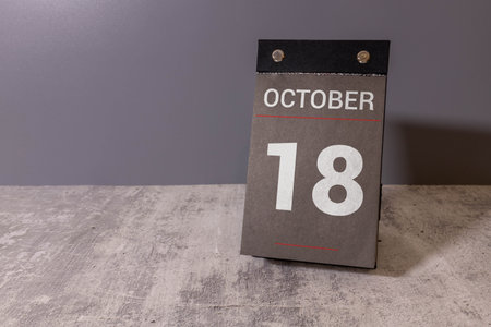 Wooden calendar with the date October 18.Monthly calendar for planning and management concept with alarm clock on wooden backgroundの写真素材