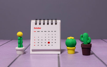 Wooden calendar organizer with date October 23 and decorative plant on tableの写真素材