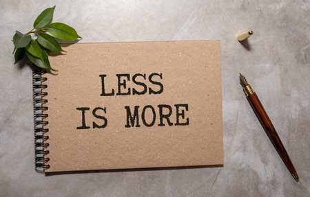 Less is More symbol. Concept words Less is More on wooden blocks. Beautiful yellow background....