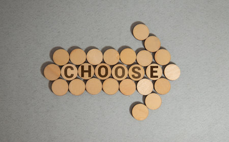Concept blue words CHOOSE WISELY on brick blocks. Beautiful blue background, wooden table. Decision making and strategy concept. Copy space.の写真素材