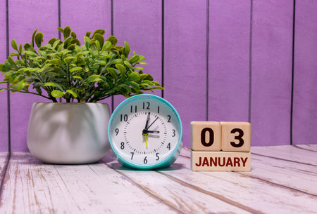 Minimalist blue wooden calendar displaying JANUARY 03 with light gray background. Date of January...