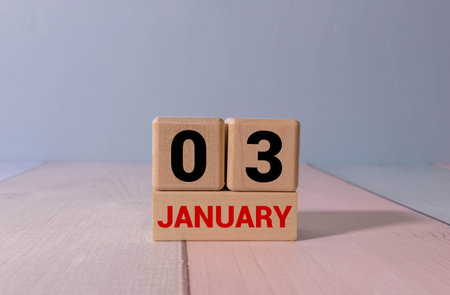 Minimalist blue wooden calendar displaying JANUARY 03 with light gray background. Date of January...