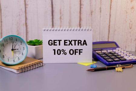 EXTRA 10 OFF percent text on a brown tag on a white paper background