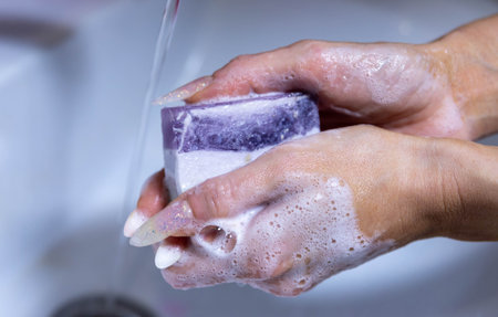 girl washing hands with soap in sink closeup.の写真素材