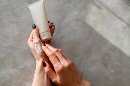 Moisturizing care skincare face cream for healing complicated troubled skin type. girl smears her hands cosmetic cream. skin care, elastic and young skin of the hands. flat lay, top view.の写真素材