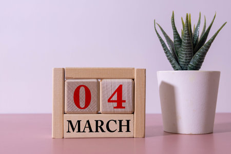 March 4th. Wooden cubes with date of 4 March on old blue wooden background