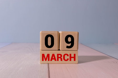 Minimalist green wooden block perpetual date calendar displaying MARCH 09 with light grey background. Date of March 9th. Day 9 of March month. Daily calendar page design for appointment date.の写真素材