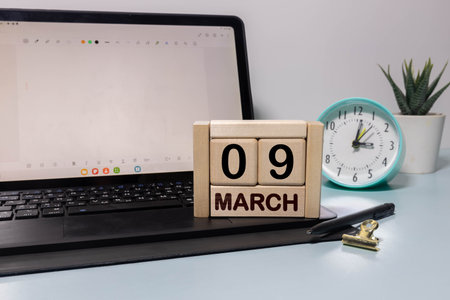 Minimalist green wooden block perpetual date calendar displaying MARCH 09 with light grey background. Date of March 9th. Day 9 of March month. Daily calendar page design for appointment date.の写真素材