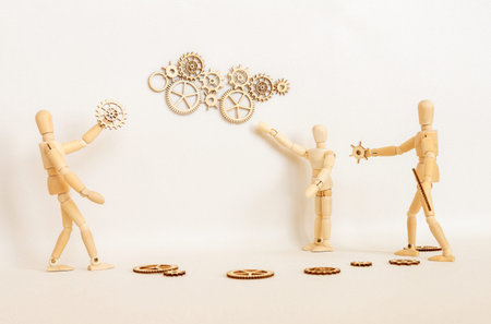 Hands holding wooden gears on wooden background,