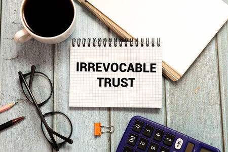IRREVOCABLE TRUST text on sticker with pen on the black background