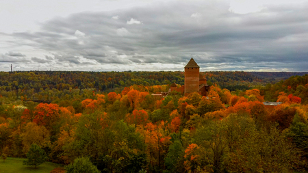Autumn Landscape View of the Old Turaida Castle , Build From Red Bricks. Surrounded by Forests Colorful Bright Yellow Orange and Green Trees, Sunny Day.  During Golden Autumn Season in Latvia, Siguldaのeditorial素材