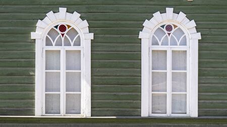 Ornamental Carved Old Antic Windows, Frames on Vintage Green Wooden Rural Houseの写真素材