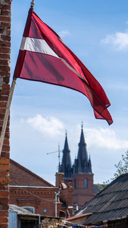 Latvia Flag and The Catholic Church Heart of Jesus Cathedral in Rezekne, Latvia. Sunny Spring Dayのeditorial素材