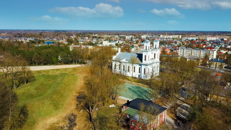 Aerial Shot of Birzai St. John the Baptist Church on the Southern Coast of the Lake Å irvÄna in Lithuania, Sunny Spring Day. Birzai City Panoramaのeditorial素材