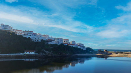 Praia De Odeceixe Mar Beach With Golden Sand, Atlantic Ocean, River Bend and White Houses of Odeceixe Village. Rota Vicentina Coast, Odemira, Portugal. Hiking Rota Vicentina the Fisherman's Trailの写真素材