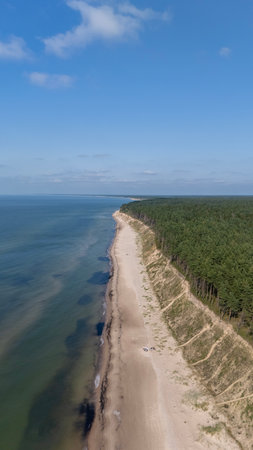 Drone Flight Over Jurkalne Steep Coastline On A Sunny Summer Day Revealing Baltic Sea Shore Sandy Trails Green Fields And Peaceful Nature Landscape In Latviaの写真素材