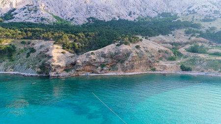 Beautiful Young Woman Hiking Trail Leading From the Beach in Baska to the Bag Mountain, Panoramic Aerial Shot, Azure Water in the Bay by the Beach in Baska on Krk Island, Croatia. Mediterranean Summerの写真素材
