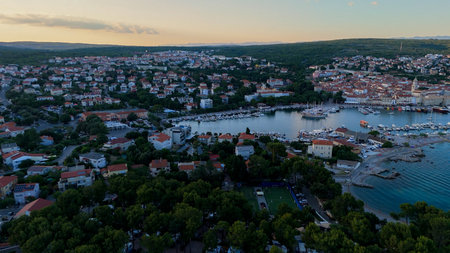 Aerial View of Krk, the Capital City of the Croatian Island of Krk, Adriatic Coast, With Harbor and Red Tiled Roofs. Blue Sea,with Sailboats, Sandy Beaches and the Historic Old Town at Sunset Croatiaの写真素材