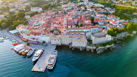 Aerial View of Krk, the Capital City of the Croatian Island of Krk, Adriatic Coast, With Harbor and Red Tiled Roofs. Blue Sea,with Sailboats, Sandy Beaches and the Historic Old Town at Sunset Croatiaの写真素材