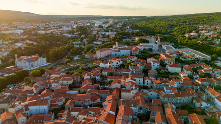 Aerial View of Krk, the Capital City of the Croatian Island of Krk, Adriatic Coast, With Harbor and Red Tiled Roofs. Blue Sea,with Sailboats, Sandy Beaches and the Historic Old Town at Sunset Croatiaの写真素材