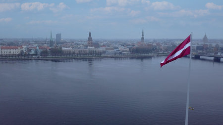 Drone View Of Riga Old Town With Latvian Flag Waving In Foreground Aerial Panorama Of Historic City Center, Daugava River And Urban Skyline On A Outumn Day In Latviaの写真素材