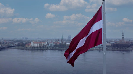Drone View Of Riga Old Town With Latvian Flag Waving In Foreground Aerial Panorama Of Historic City Center, Daugava River And Urban Skyline On A Outumn Day In Latviaの写真素材