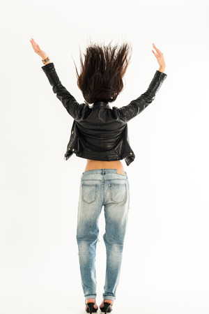 Young woman in leather jacket and jeans from behind. isolated on white backgroundの写真素材