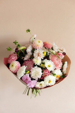 Lush bouquet of pink and white cosmos and dahlia flowers on a pink background.の写真素材