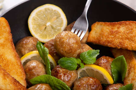 Homemade meatballs in frypan with lemon and mint.の写真素材