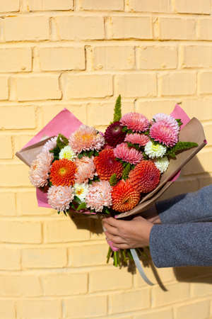 Hands holding beautiful bouquet of autumn flowersの写真素材