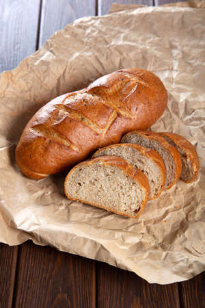 Bread and bakery in craft paper on brown wooden background.の写真素材