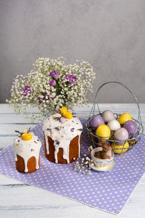 Easter purple and yellow eggs and cakes on purple polka dot napkin.