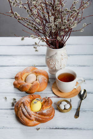 Easter cake with yellow eggs and willow on white wooden background.の写真素材