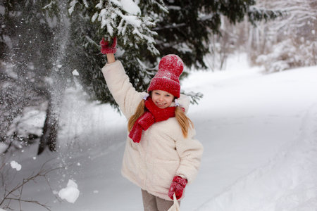Smiling girl in a snowy forest in winter.の写真素材