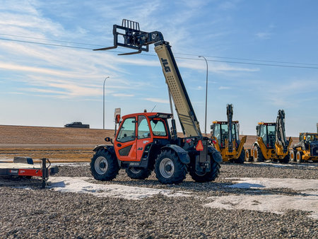 Regina, Canada - February 2026: JLG telehandler with extended boom and forks on a construction site,...