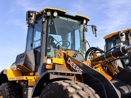 Regina, Canada - February 2026: Close-up of John Deere wheel loader showing cabin, hydraulic arm,...