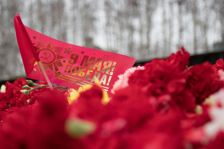 red flag with red carnations on the monument, victory day, editorial, Khanty-Mansiysk, may 9, 2017のeditorial素材