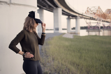 portrait of girl in hat in profile at sunset and fields with tall grassの写真素材