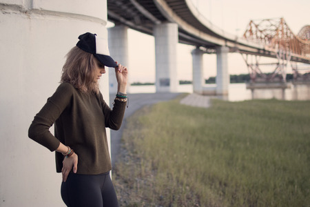 portrait of girl in hat in profile at sunset and fields with tall grassの写真素材