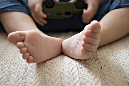 baby's heel on the background of the hands that hold the machineの写真素材