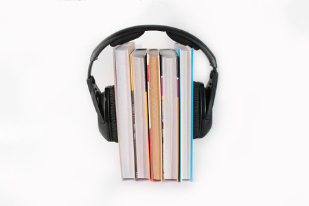 five books on a white background vertically on top of them surround headphonesの写真素材