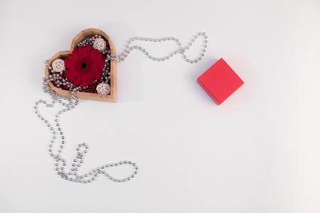 wooden box heart shape with beads and flower gerberas and red box and other items on a white backgroundの写真素材