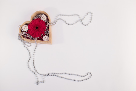 wooden box heart shape with beads and flower gerberas and red box and other items on a white backgroundの写真素材