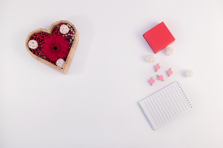 wooden box heart shape with beads and flower gerberas and red box and other items on a white backgroundの写真素材