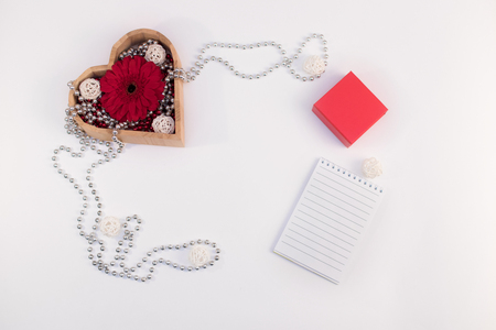 wooden box heart shape with beads and flower gerberas and red box and other items on a white backgroundの写真素材