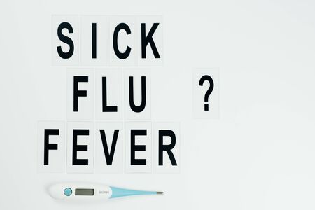 black question  sick, flu, fever  in the middle  with thermometer  on white backgroundの写真素材