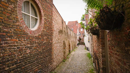 Empty Narrow Medieval Street Between Brick Houses In Bruges, Belgiumの写真素材